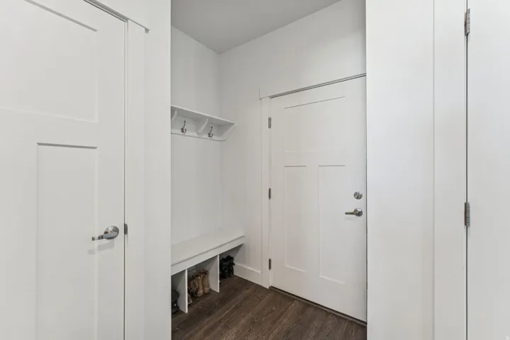 Mudroom featuring a built-in bench, integrated storage cubbies, and wall-mounted coat hooks