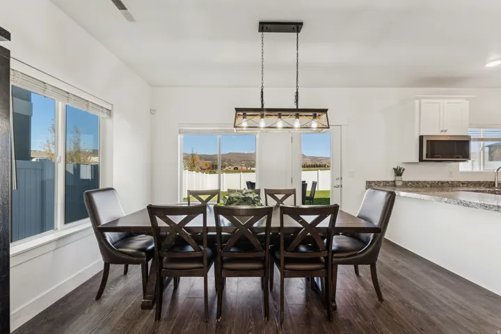 Wood-finish flooring, white walls, and a multi-light linear chandelier