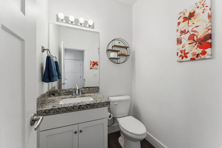 Vanity with a granite countertop, undermount sink, and chrome faucet