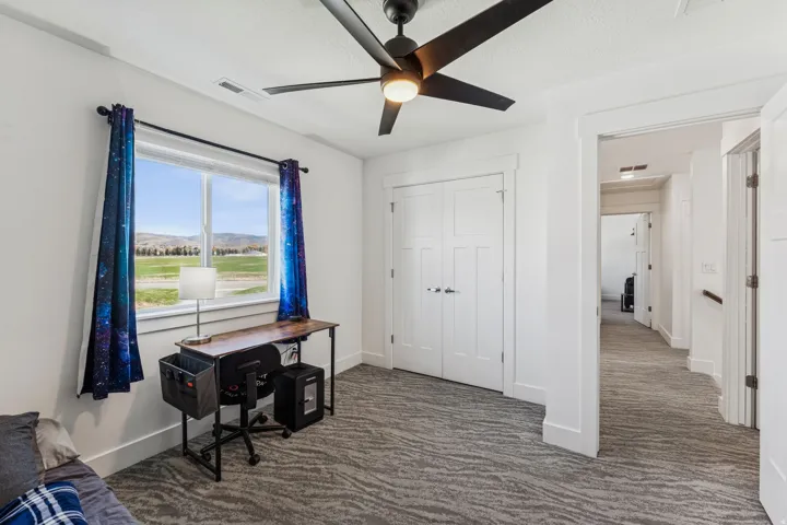 Spacious room featuring a ceiling fan, white trim, and a window with a mountain backdrop