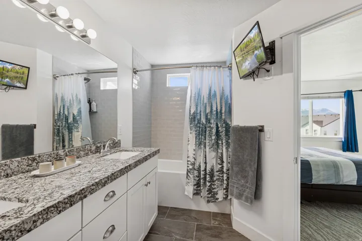 Dual vanity with stone-finish countertop, undermount sinks, and white cabinetry