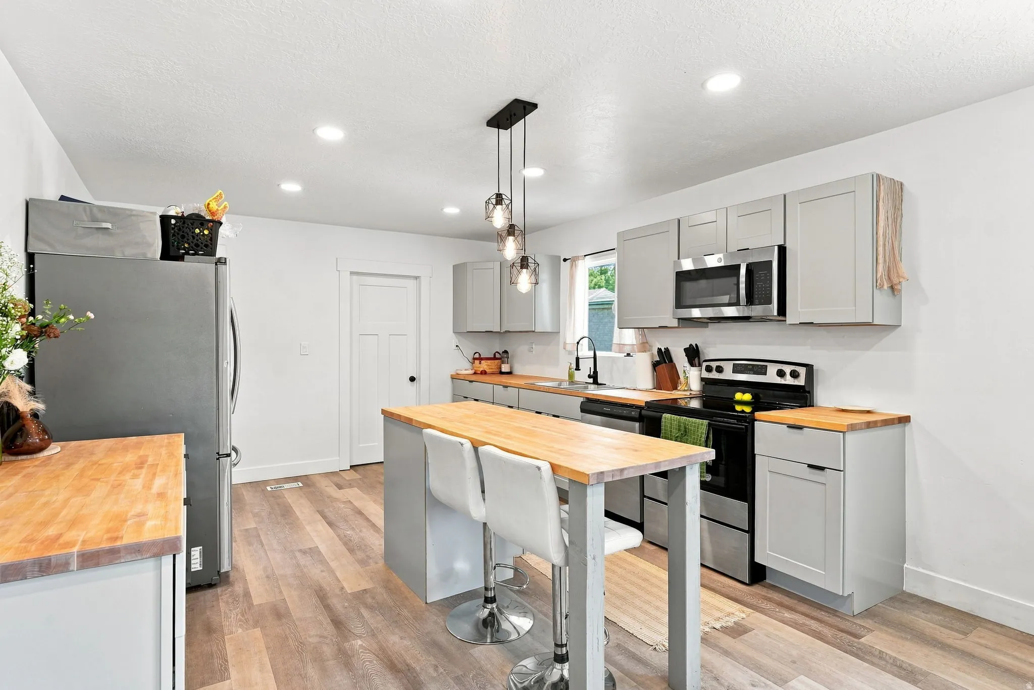 Kitchen featuring light wood-finish flooring, recessed lighting, and a kitchen island with wood-finish countertop