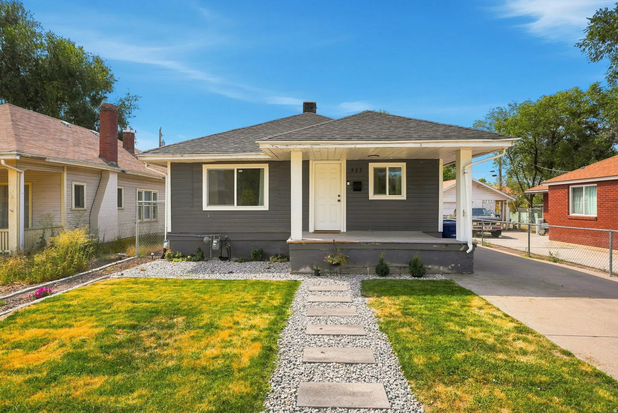 Single-story residence featuring dark gray siding, a covered front porch, and white trim accents