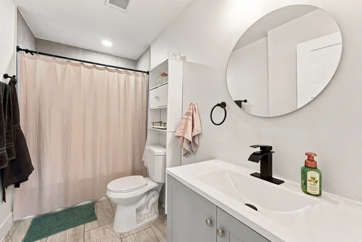 Modern bathroom featuring a floating vanity with rectangular vessel sink, quartz countertop, and matte black wall-mounted faucet