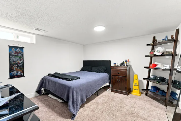 Recessed ceiling light, high-set horizontal window, wall-to-wall carpeting, white painted walls, and wood-finish shelving unit