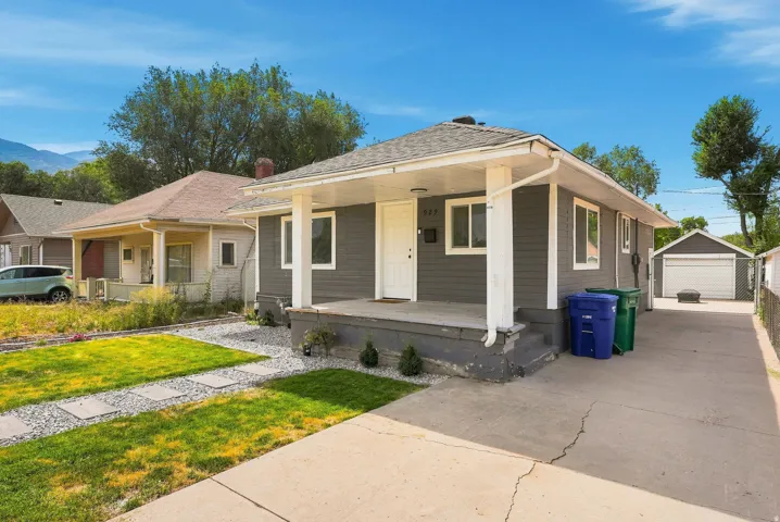 Front exterior with gray siding, white trim, and a covered porch