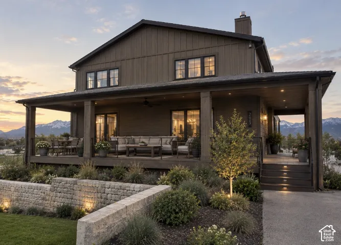 Multi-level outdoor living space featuring a covered porch, wood-finish columns, and recessed lighting. Photo is digitally altered to show furniture