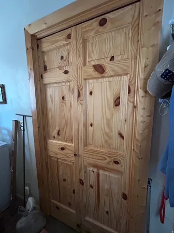 Wood-finish bi-fold doors featuring panel detailing and a light wood-finish frame