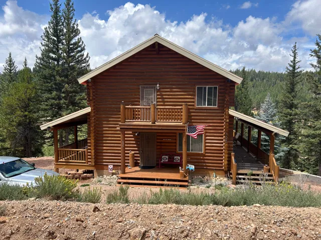 Log cabin exterior with a covered porch and upper balcony