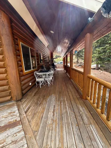 Expansive wood-plank porch with log siding and natural wood railings