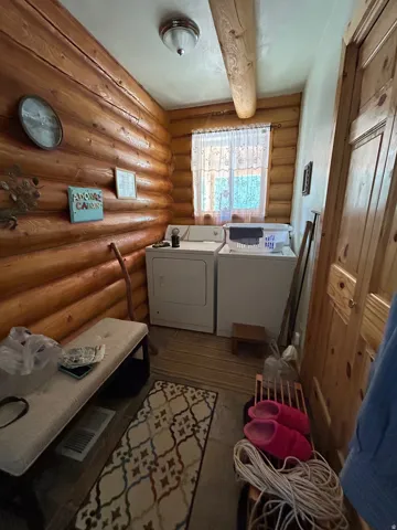 Wood-finish log walls and ceiling beam, recessed window, and flush mount ceiling light