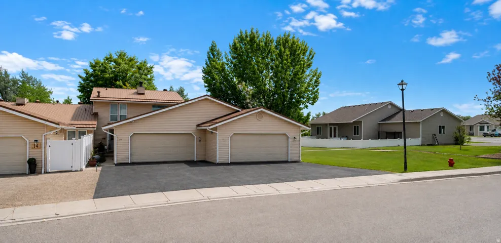 Multi-unit property featuring metal roofing, light-toned siding, and attached garages