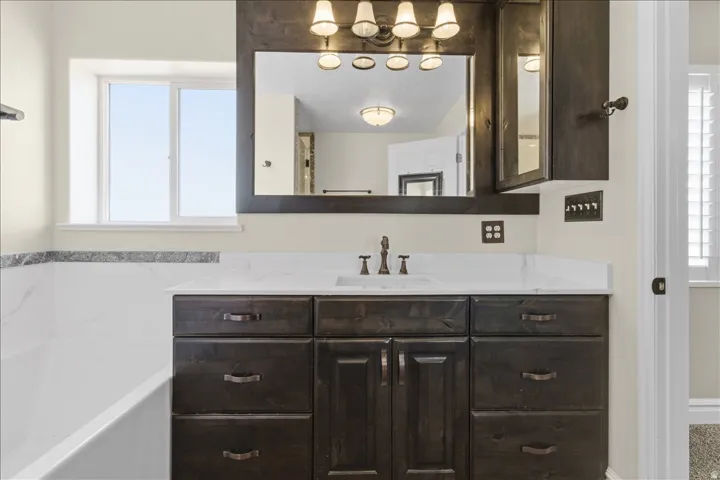 Dark wood-finish vanity with a white countertop and integrated sink