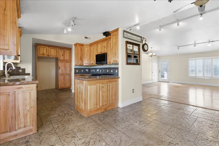 Kitchen featuring wood cabinetry, stone countertops, and tile flooring