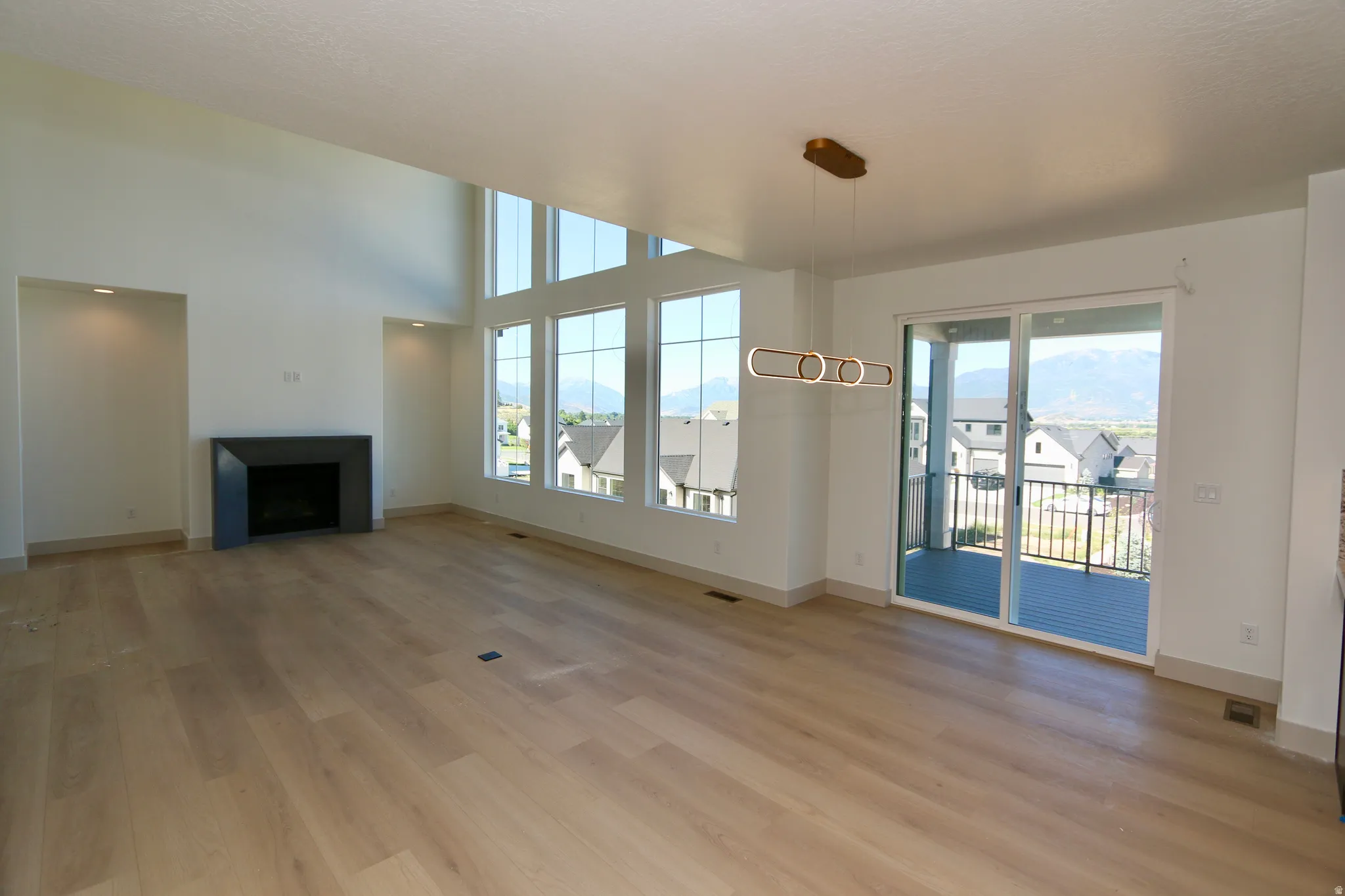 Dining area with a modern over-table light and a sliding glass door to an outdoor deck with BBQ