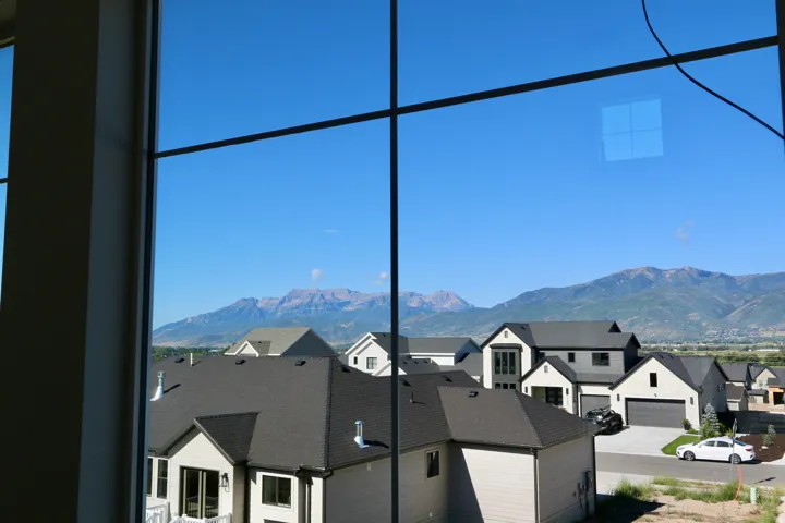 Expansive window framing distant mountains and surrounding properties
