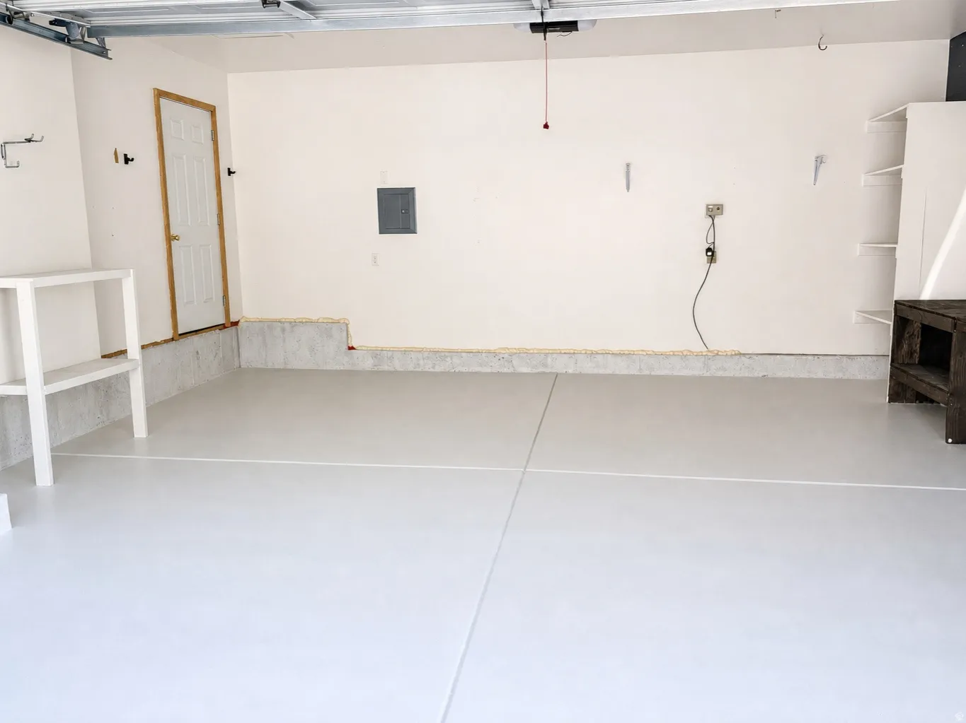 Attached garage with light gray flooring and white walls