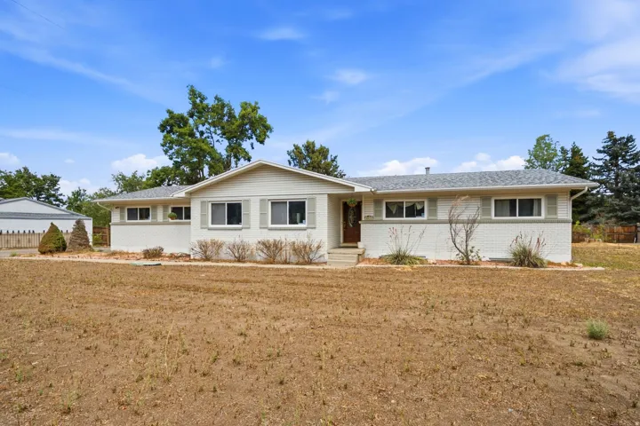Ranch-style residence featuring a prominent front gable, white exterior brick, and a gray shingle roof