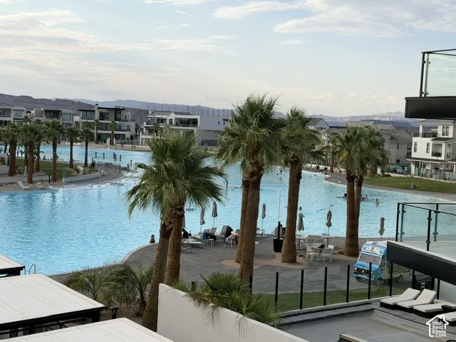 Expansive lagoon with a paved perimeter, surrounded by mature palm trees and residential structures