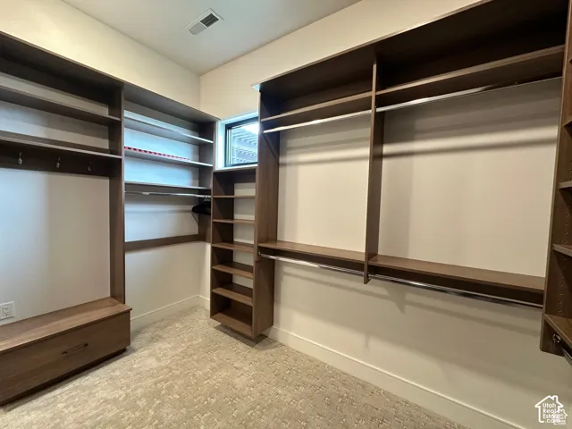 Built-in closet system with varied shelving, multiple hanging rods, and an integrated bench storage unit