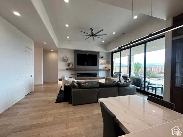 Expansive living area with wood-finish flooring, recessed lighting, and a modern ceiling fan