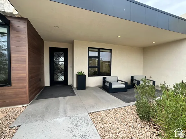 Covered entry with recessed lighting, stucco exterior, wood-finish siding, and decorative glass entry door