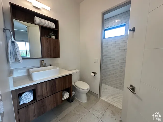 Floating wood-finish vanity with a rectangular vessel sink and quartz countertop