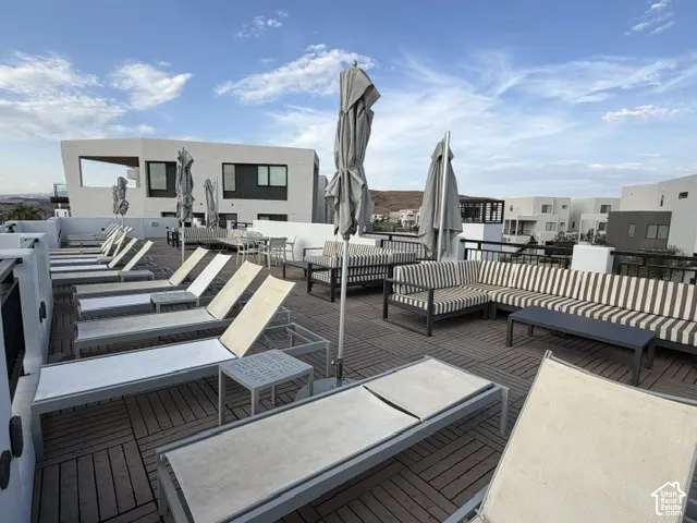 Rooftop deck featuring a slatted wood-finish surface, perimeter railing, and modern architecture