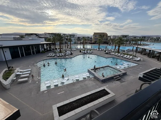 Expansive outdoor pool deck featuring a swimming pool, integrated spa, and multiple lounge areas