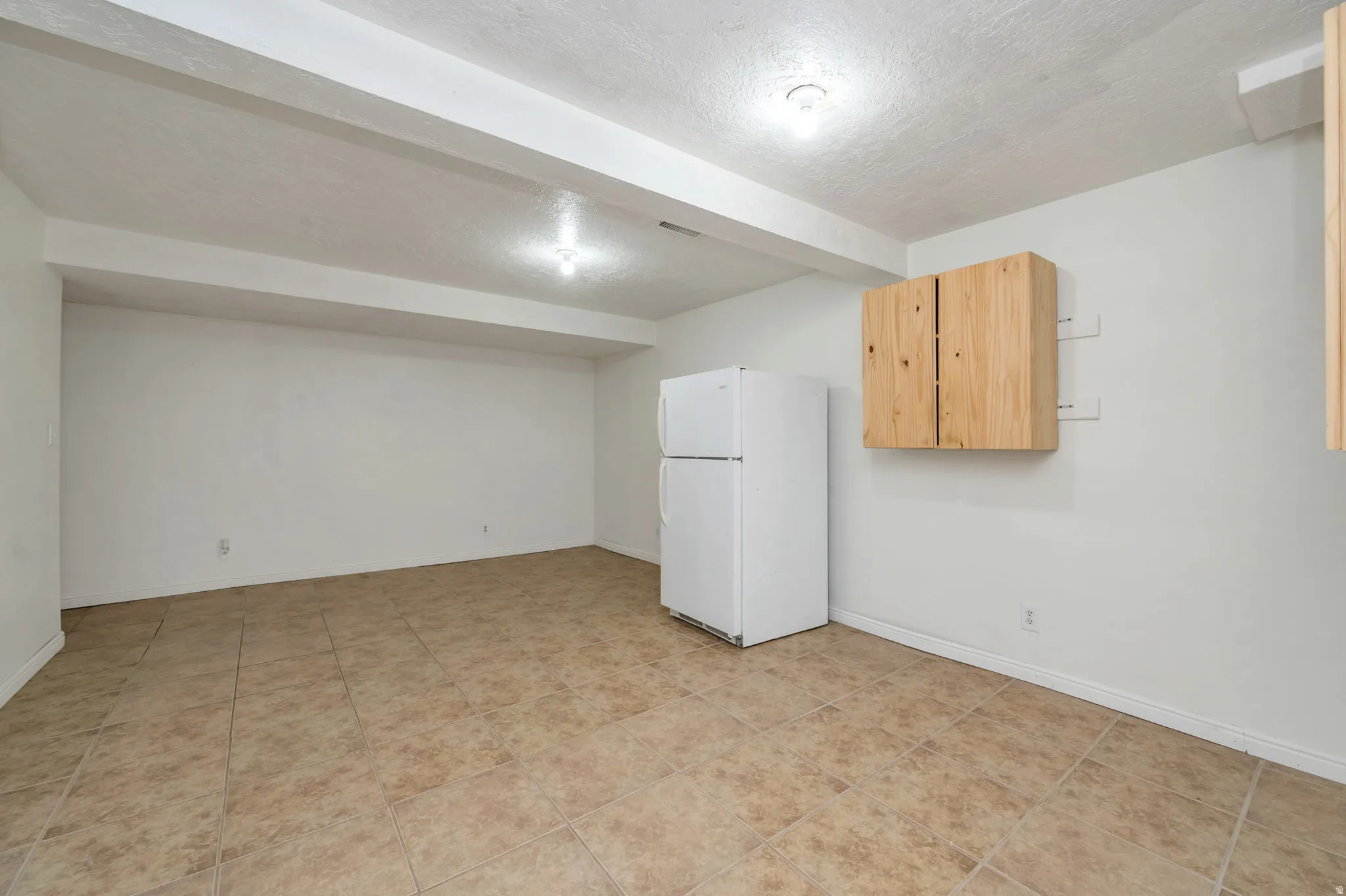 Tile flooring, recessed ceiling lighting, light wood-finish cabinetry
