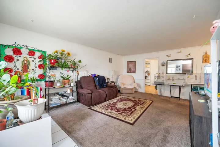 Spacious living room with neutral carpet flooring, recessed ceiling lighting, and large windows providing natural light