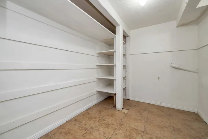 Built-in shelving, tile flooring, and white walls