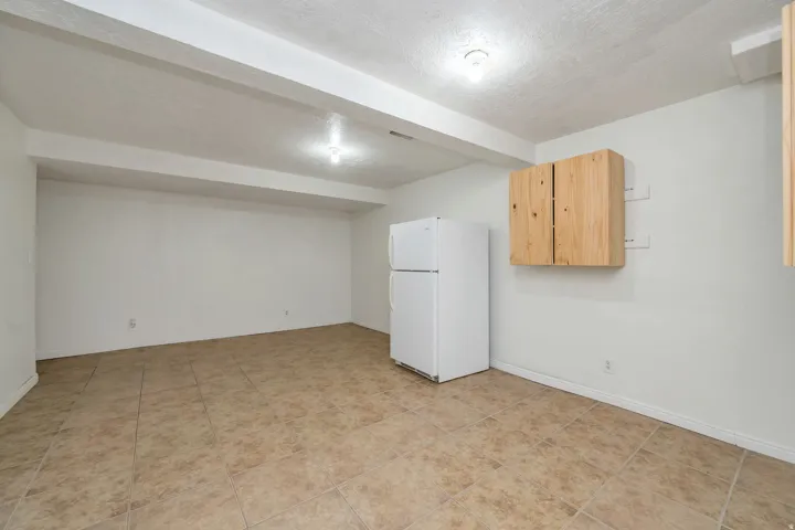 Tile flooring, recessed ceiling lighting, light wood-finish cabinetry