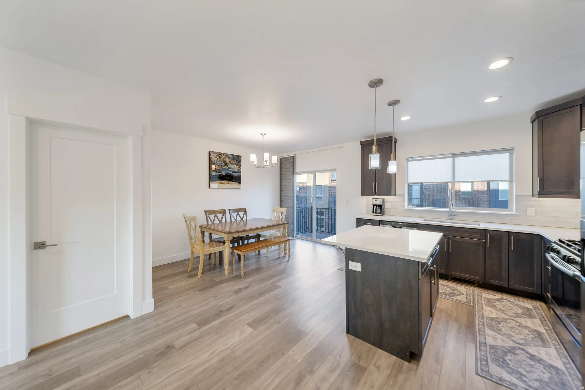 Open-concept living area featuring wood-finish flooring, recessed lighting, and a sliding glass door