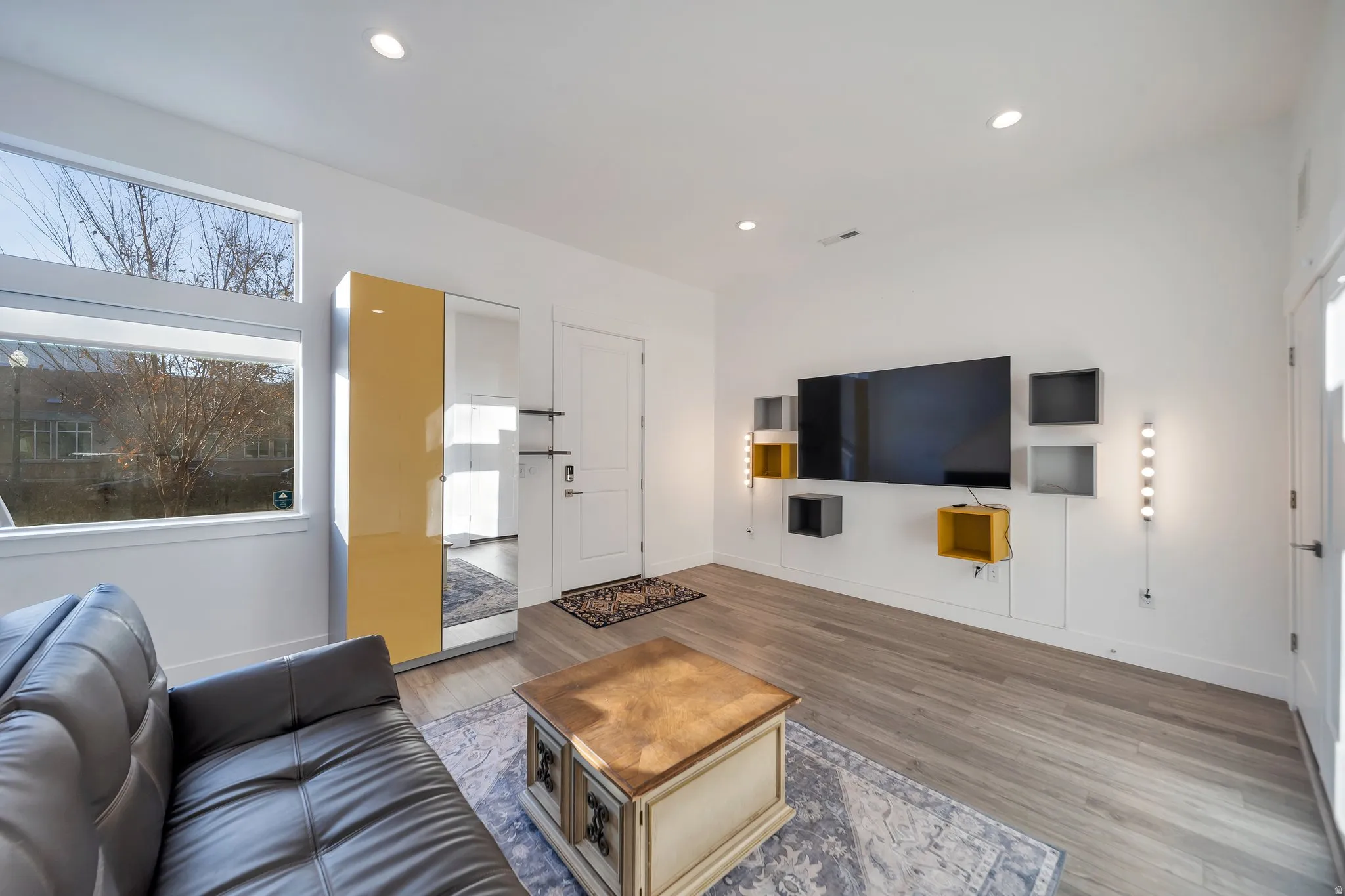 Recessed lighting, wood-finish flooring, and white walls