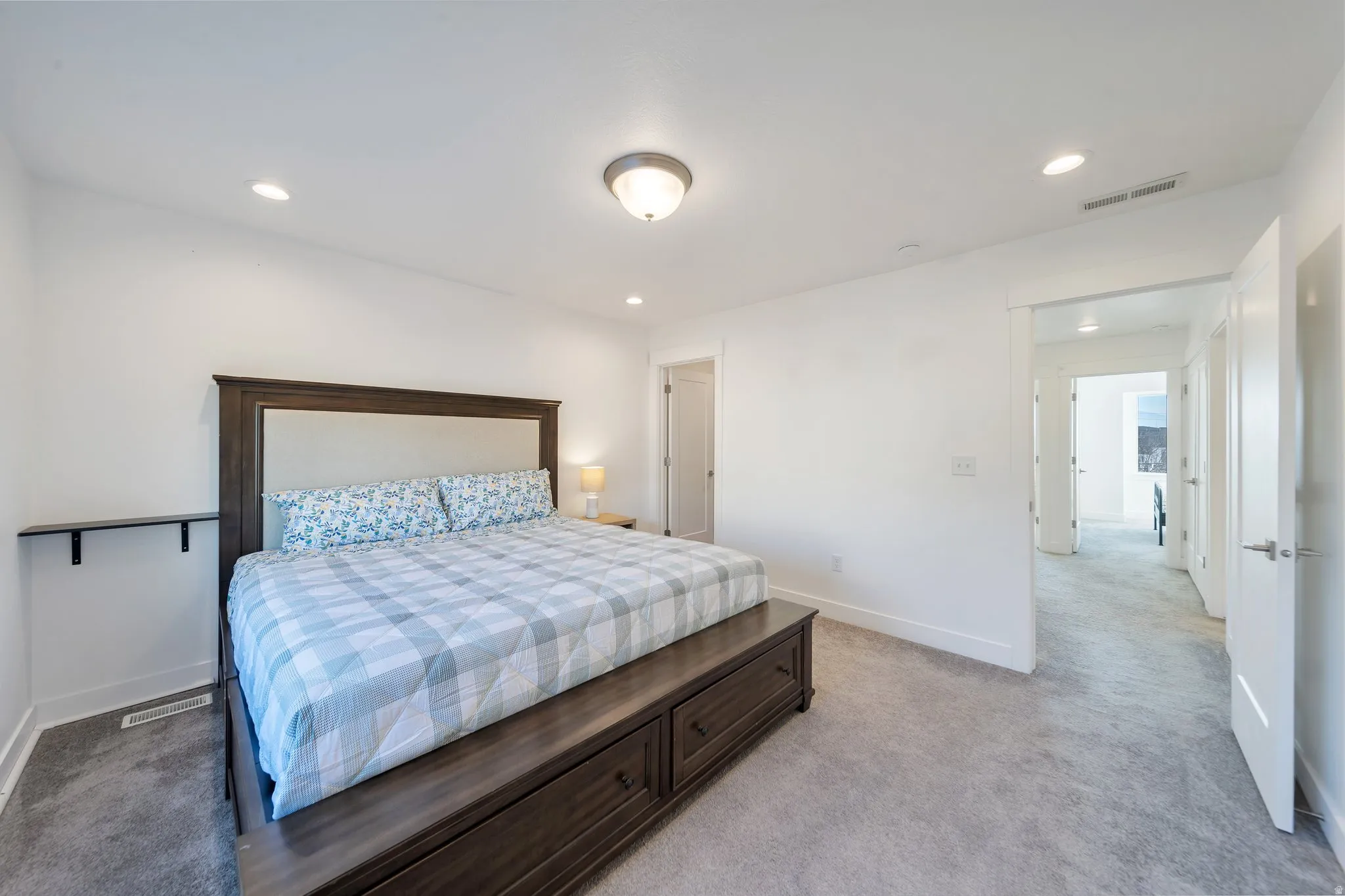 Plush carpeting, recessed lighting, white walls, and a ceiling-mounted light fixture