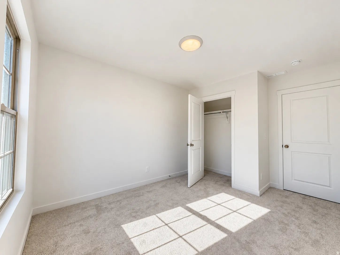 Neutral wall finishes, recessed lighting, and soft carpet flooring