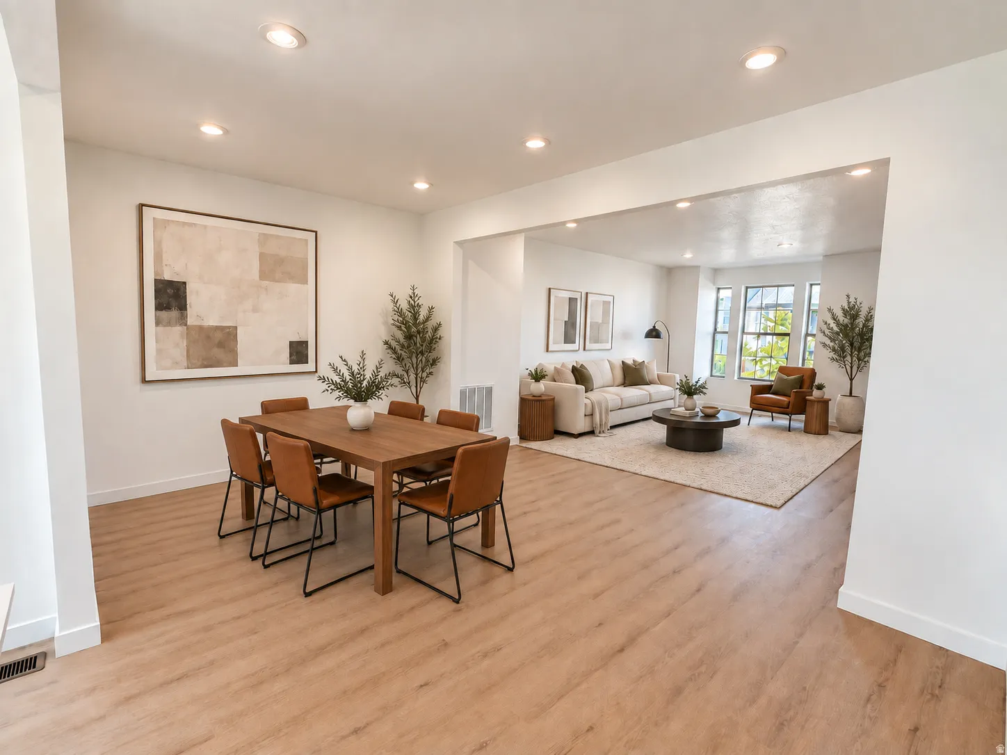 Open-concept living space with recessed lighting, wood-finish flooring, and large windows