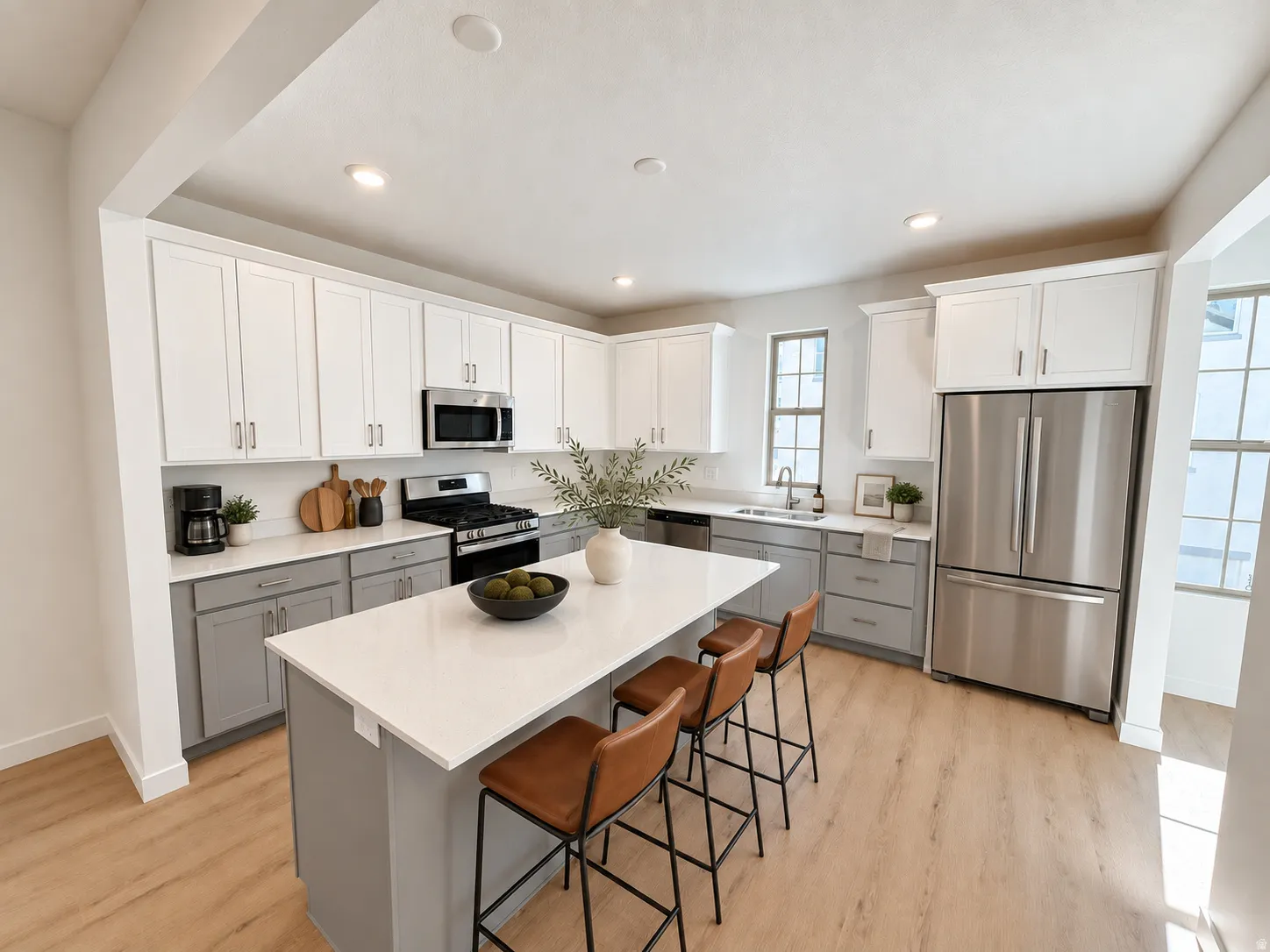 Modern kitchen featuring two-tone cabinetry, stainless steel appliances, a center island with countertop seating, recessed lighting, and wood-finish flooring