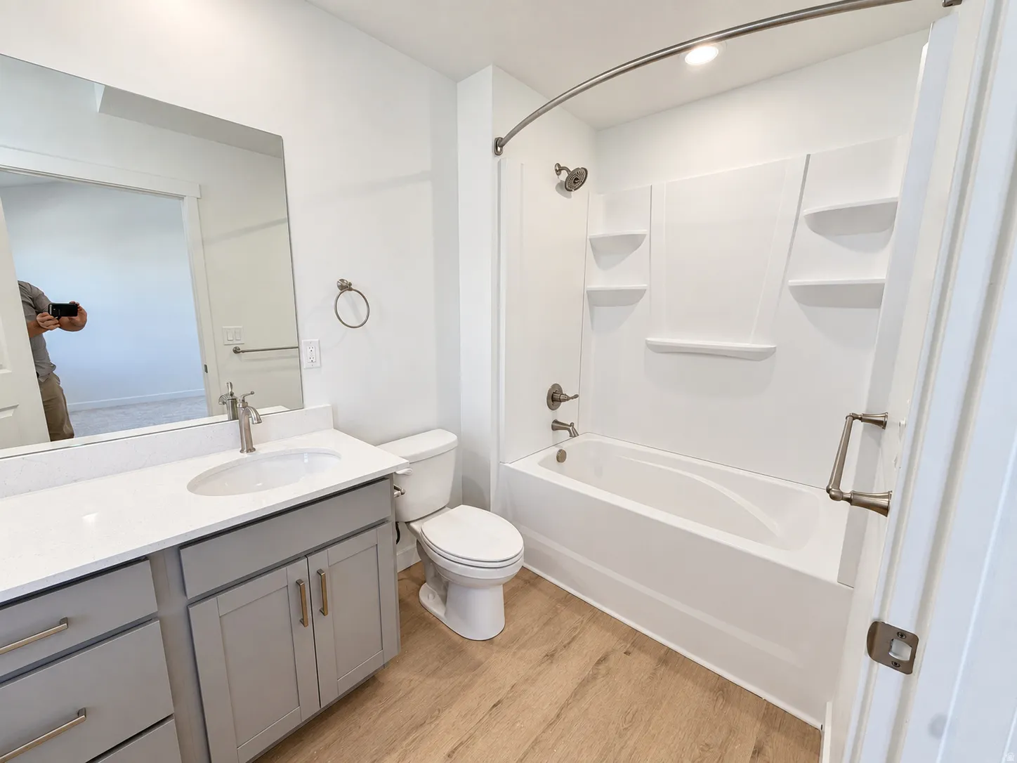 White vanity with a solid surface countertop, undermount sink, and brushed nickel faucet