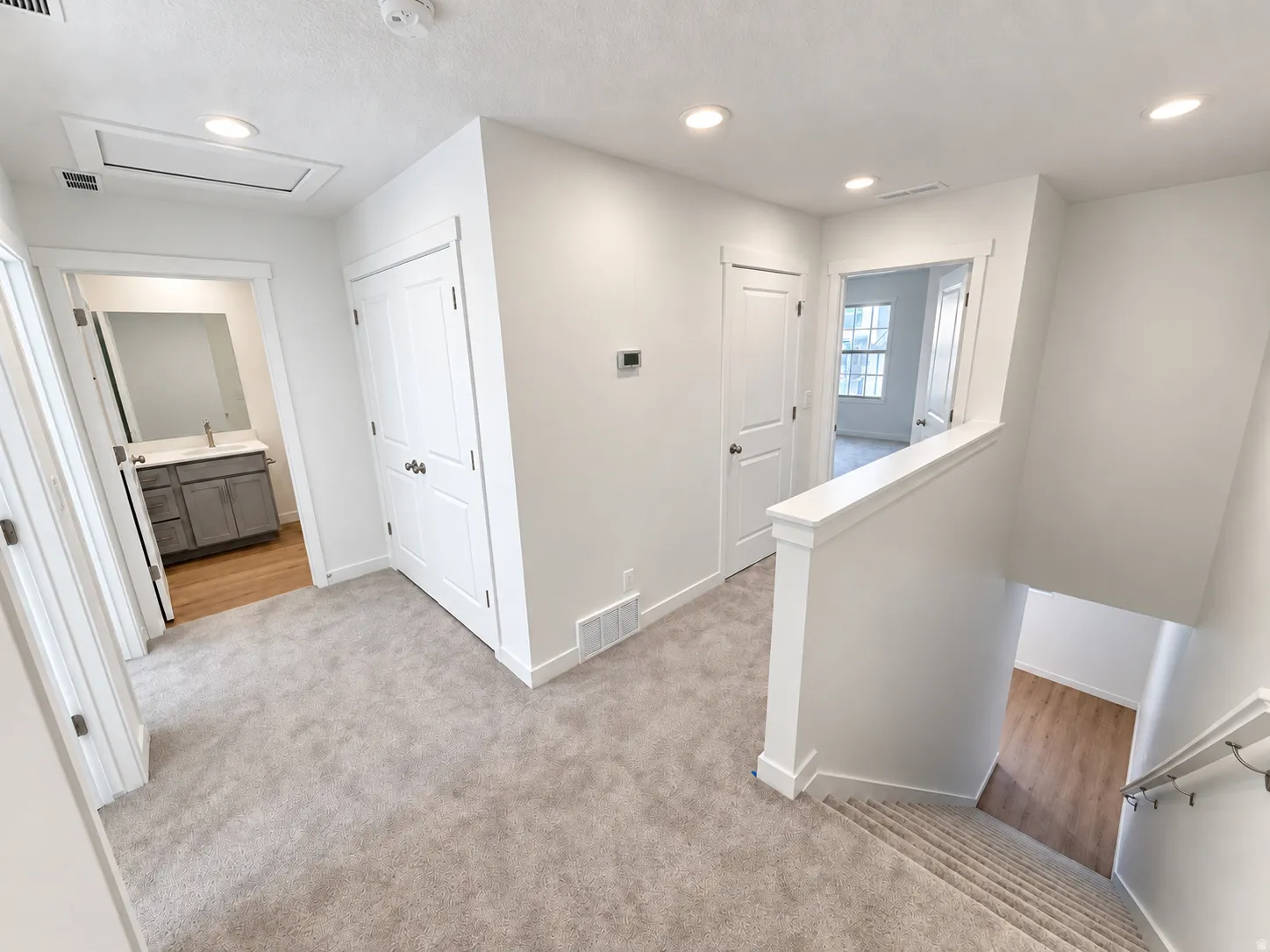 Neutral color palette, recessed lighting, carpeted flooring, wood-finish flooring, white paneled doors