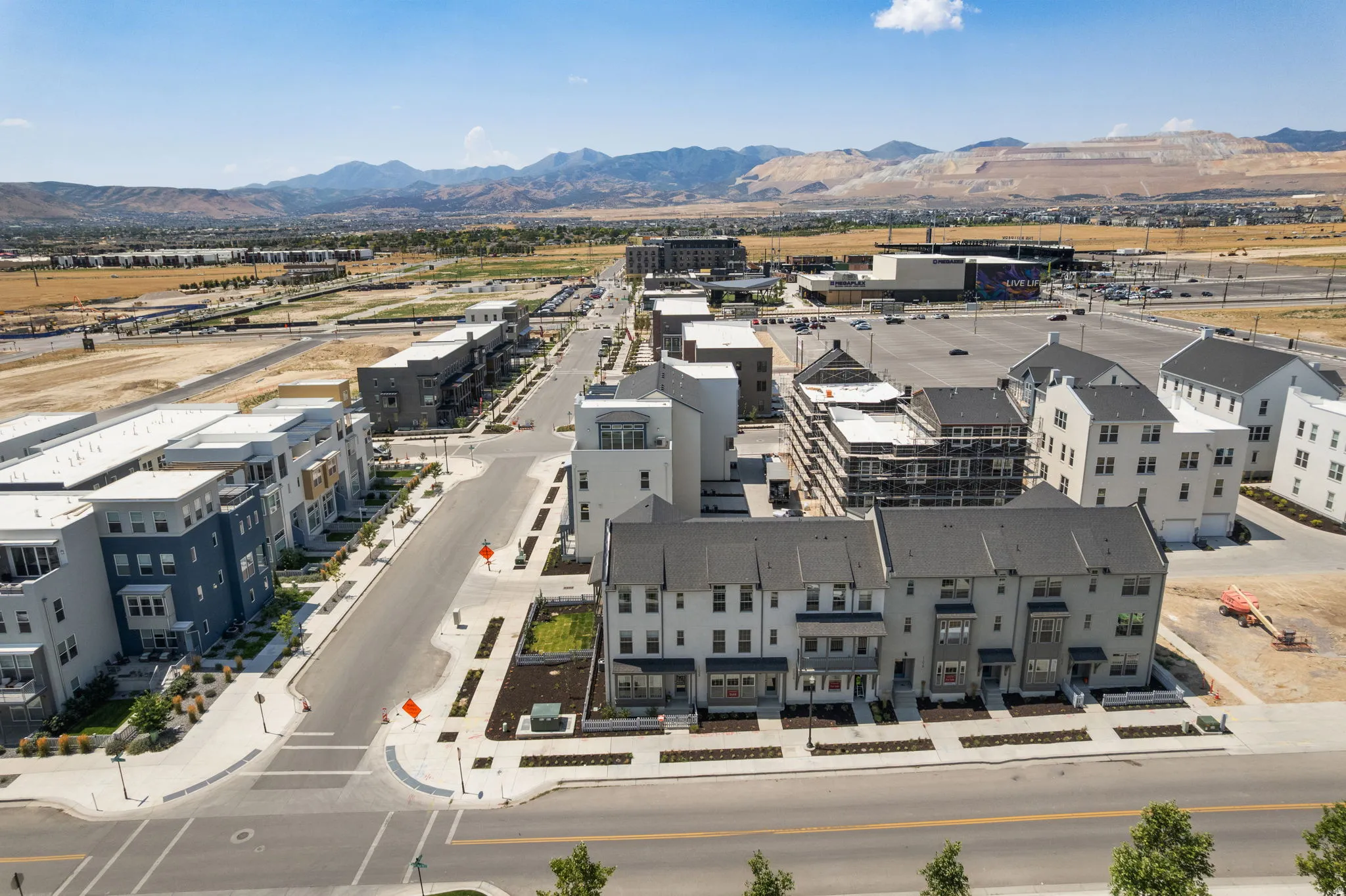 Expansive mixed-use development featuring multi-story residences, commercial structures, and wide paved roadways