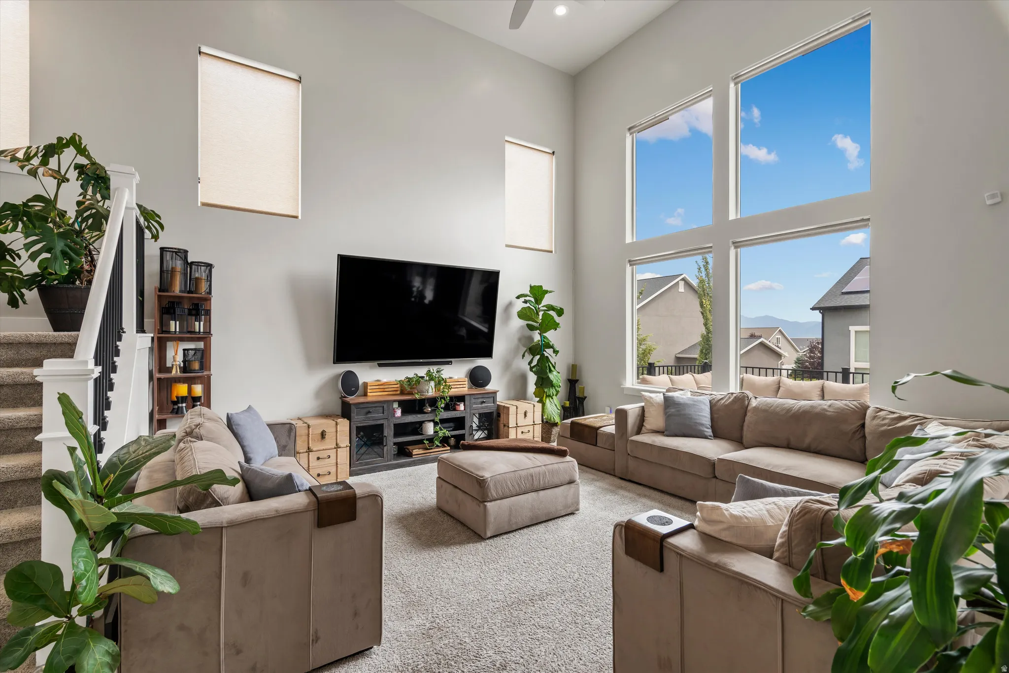 The living room features soaring ceilings, large windows, an abundance of natural light, and east facing views!