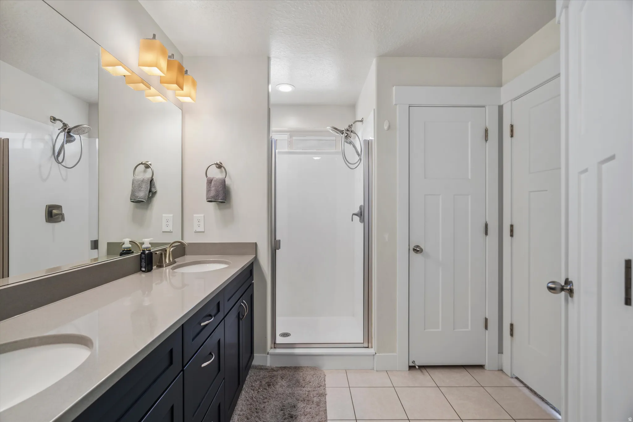 Primary bath features dual sinks, quartz countertops and a water closet.