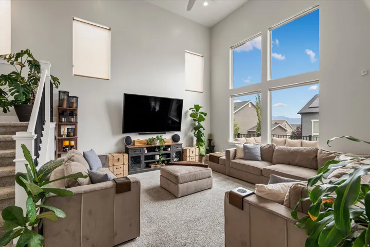 The living room features soaring ceilings, large windows, an abundance of natural light, and east facing views!