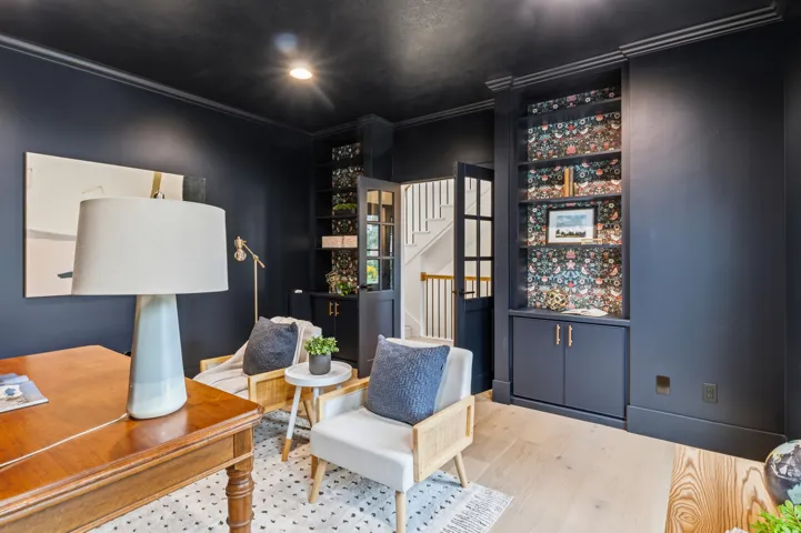 Richly painted walls with crown molding and light wood-finish flooring