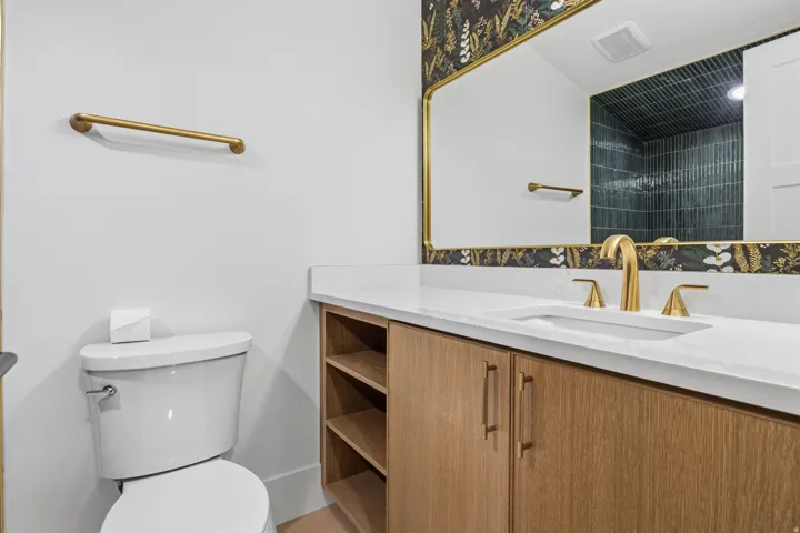 Wood-finish vanity with open shelving, a white countertop, and a rectangular undermount sink