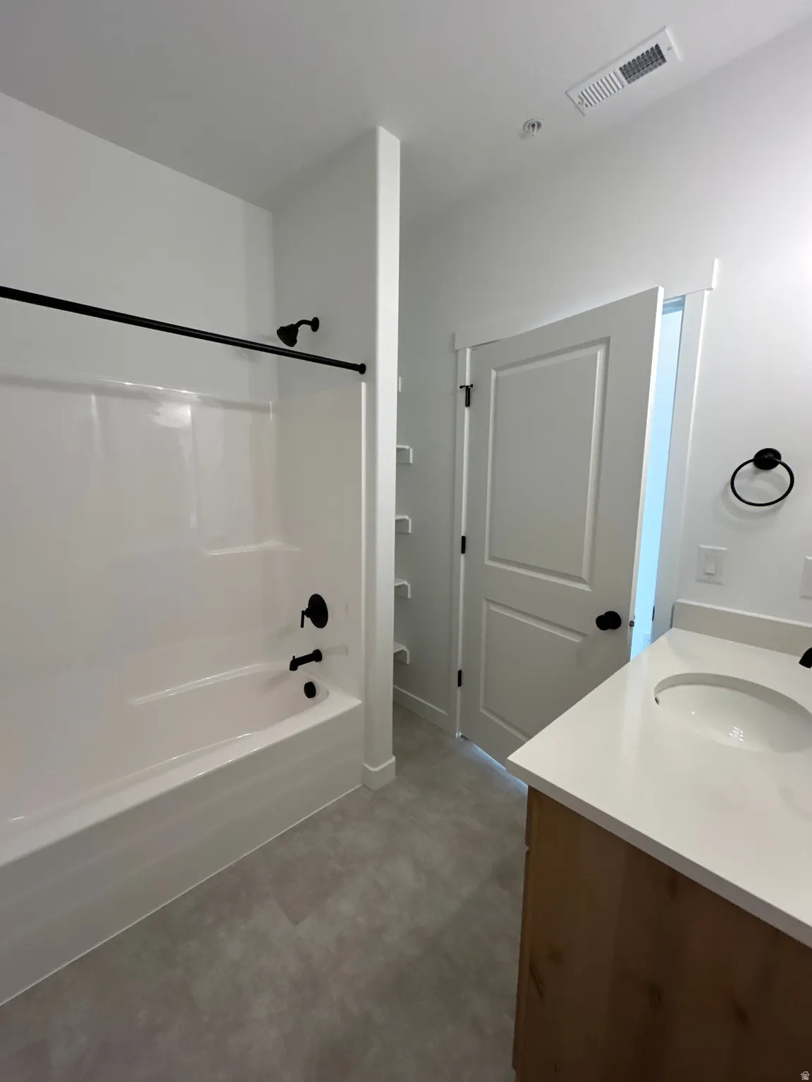 White bathtub and shower combination with matte black fixtures