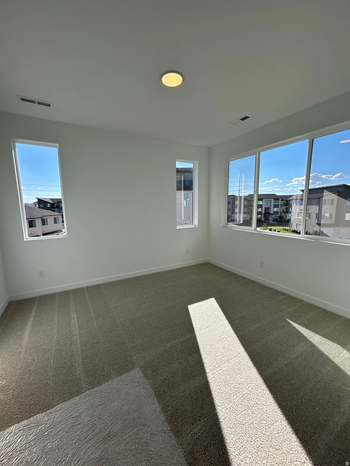 Neutral tone wall finishes, carpeting, and multiple windows