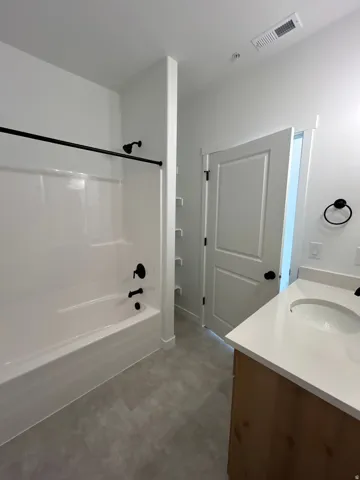 White bathtub and shower combination with matte black fixtures